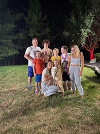 a group of people posing for a photo in a yard at night